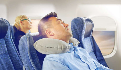 man-slepping-on-a-plane-using-travel-pillow